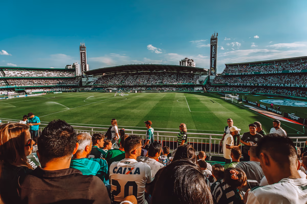A packed football stadium under a blue sky on a sunny match day
