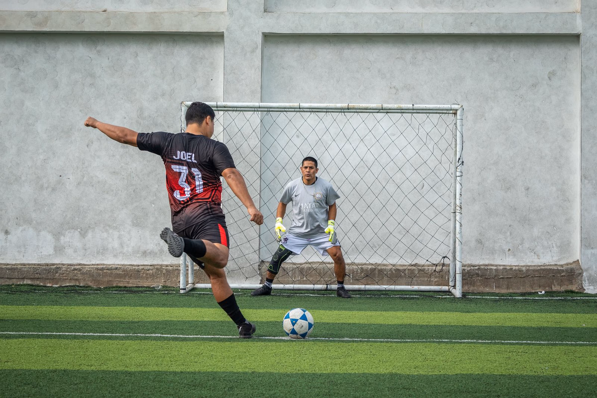 A player steps up to take a penalty kick as the goalkeeper waits to save on the line