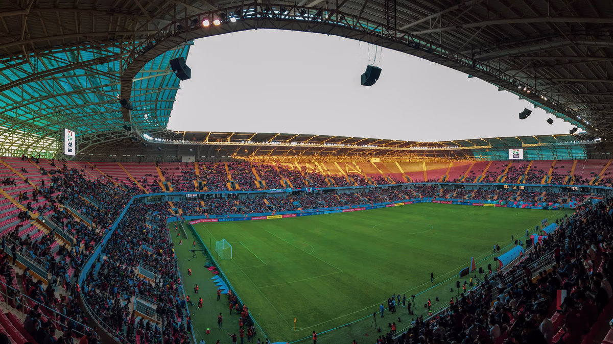 A packed stadium of fans cheering during a major football match