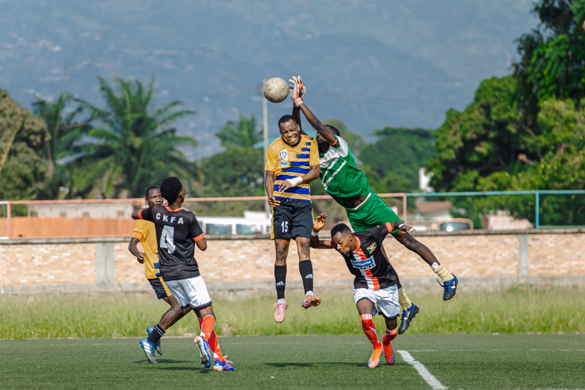 Footballers jump to contest a header inside the penalty area