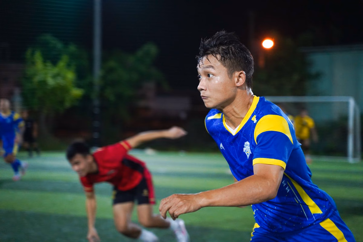 An intense football match under night floodlights, two teams contesting the ball in midfield