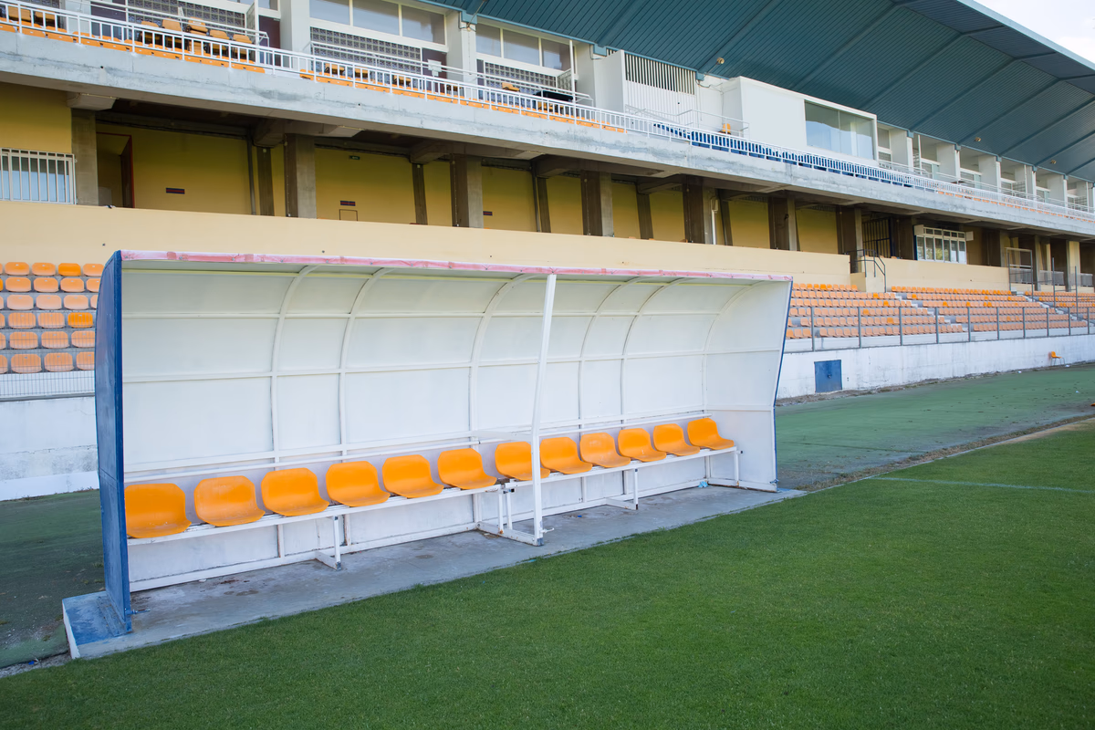 An empty technical area and substitutes' bench before a football match begins