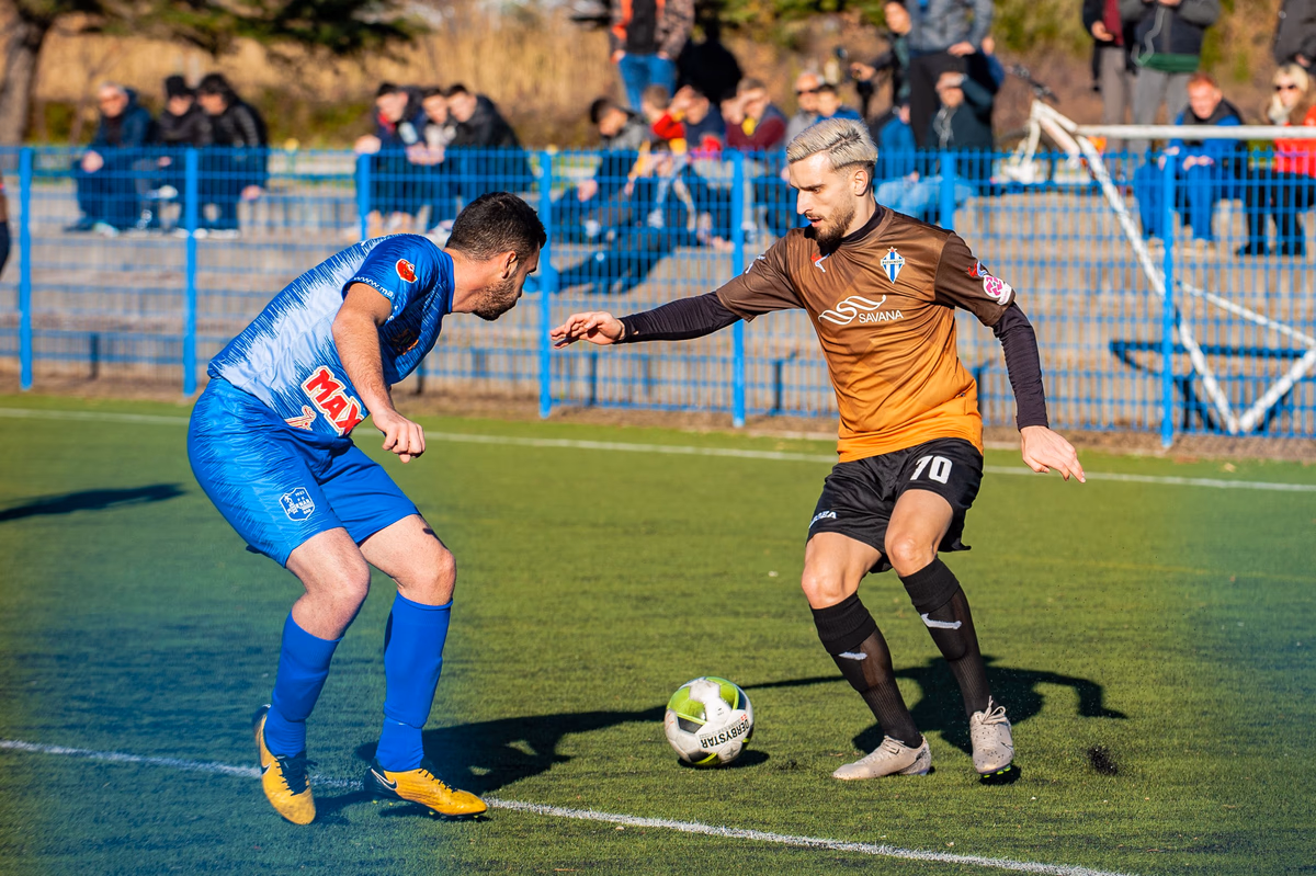 Two footballers battling fiercely for the ball down the touchline