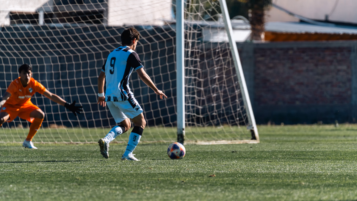 A striker firing a shot at goal during a decisive moment of a football match