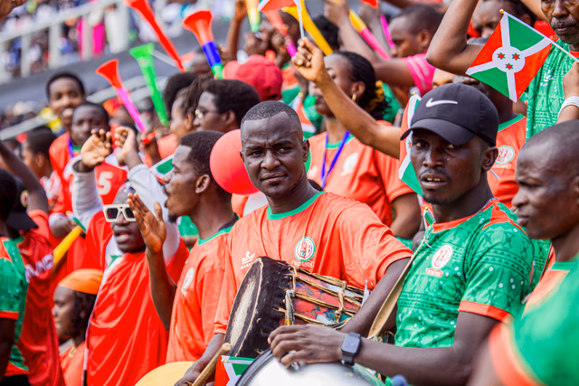 African football supporters beating drums and waving flags in the stands on a matchday