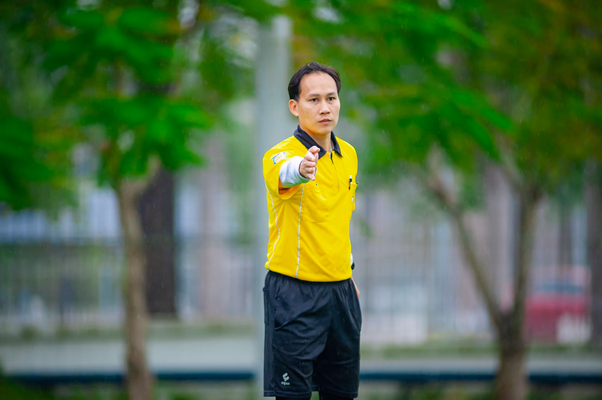 A football referee signaling a decision on the pitch during a match