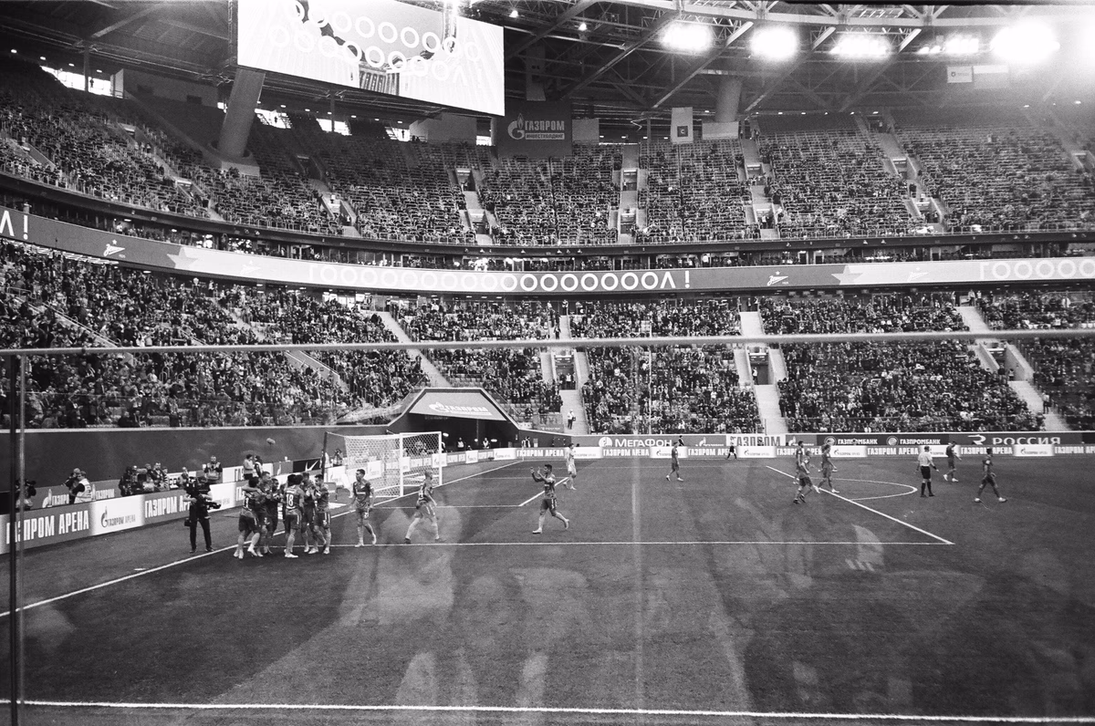 A wide view of a large stadium packed with supporters during a football match