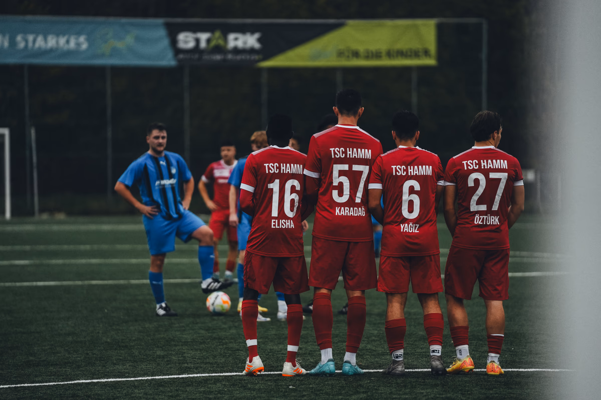 A line of outfield players standing shoulder to shoulder forming a defensive wall at a free kick