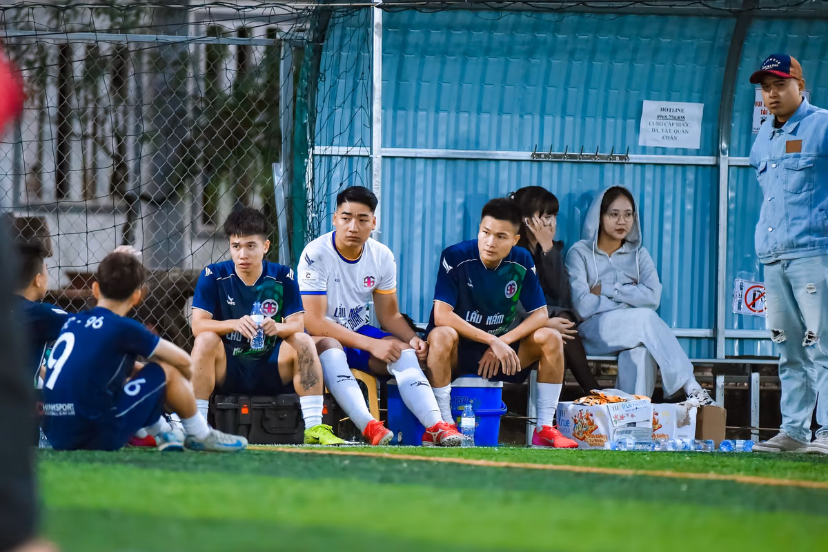 Substitute footballers sitting and waiting on the sideline bench during a match